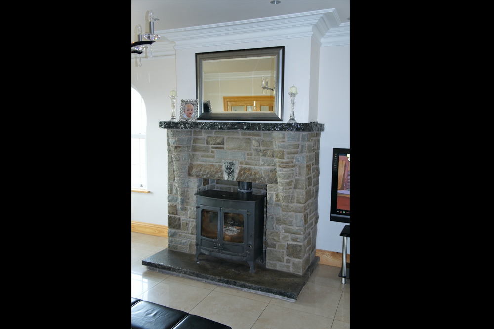 Green Portlaoise stone. Coned corbel detail. Rock faced limestone mantle and hearth with 3 piece self supporting flat arch