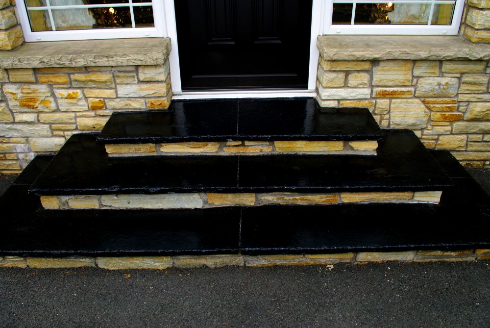 Steps formed using black limestone treads and a stone riser